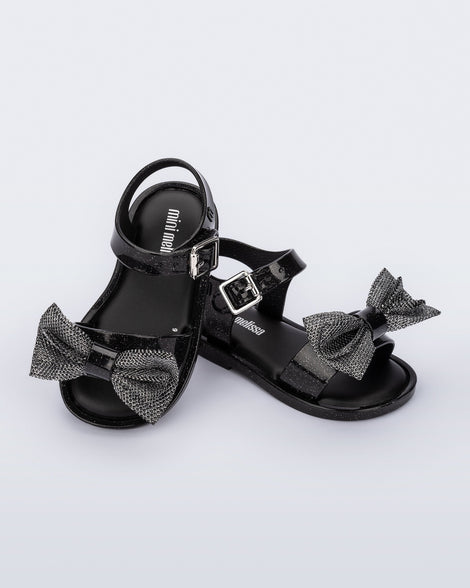 Angled view of a pair of glitter black Mar Sweet baby sandals