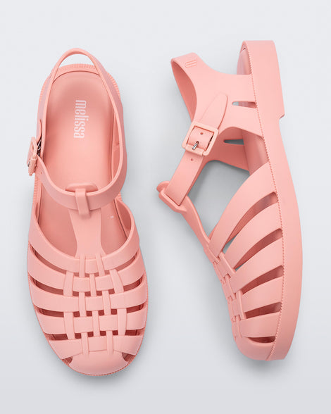 Side and top view of a pair of light pink Possession sandals