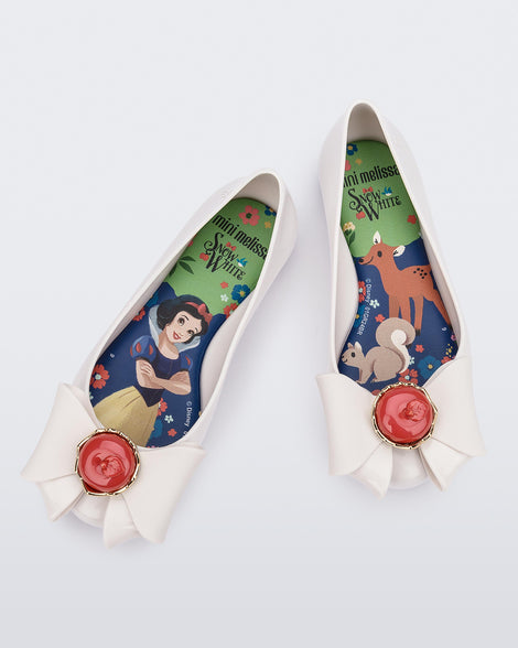 Top view of a pair of white Sweet Love Snow White kids flats with a white bow with red apple center