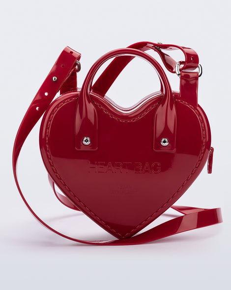 Back view of a red Heartbeat bag with small handles and longer strap.