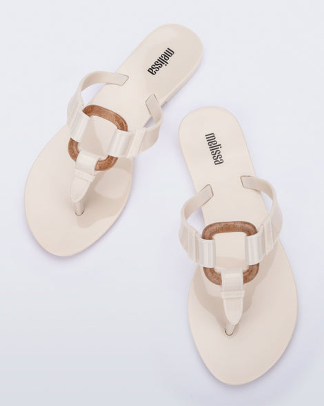 Top view of a pair of beige Olivia adult flip flops