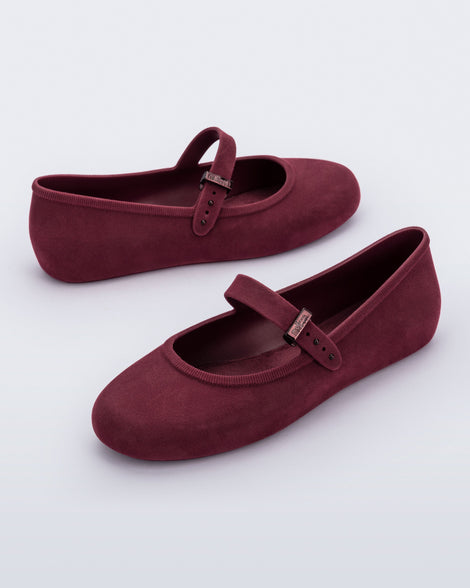 Side angled view of a pair of burgundy red Soft Ballerina Velvet flats