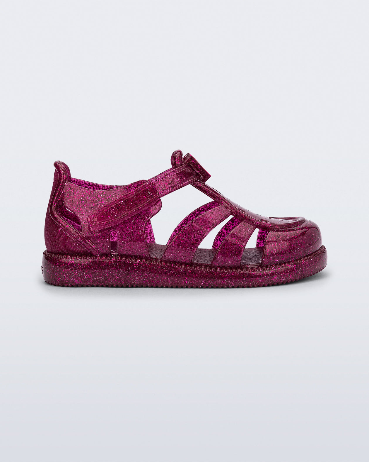 Side view of a glitter pink baby Hip Daydream sandal