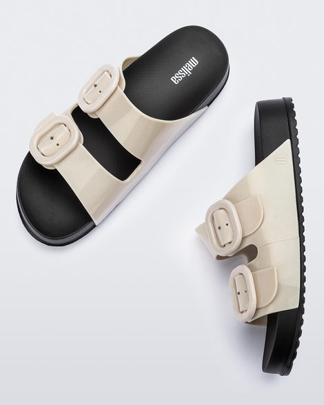 Top and side view of a pair of black sole with beige upper Cozy slides.