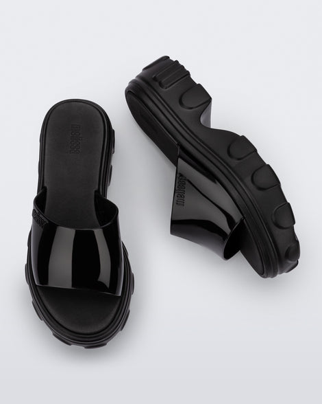 Side and top view of a pair of black Ella slide platforms