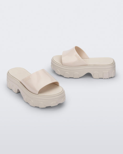 Side and angled view of a pair of beige Ella slide platforms