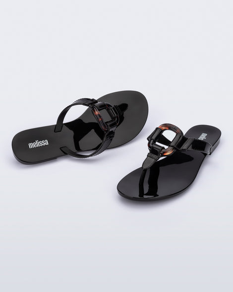 Angled view of a pair of black Olivia adult flip flops