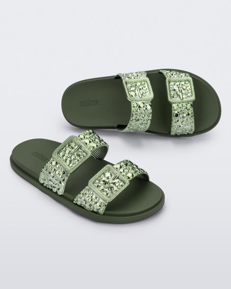 Top and angled view of a pair of green Lust Slide with metallic buckle straps