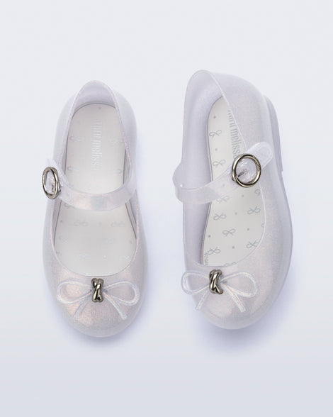 Top and side view of a pair of pearly clear baby Sweet Love flats