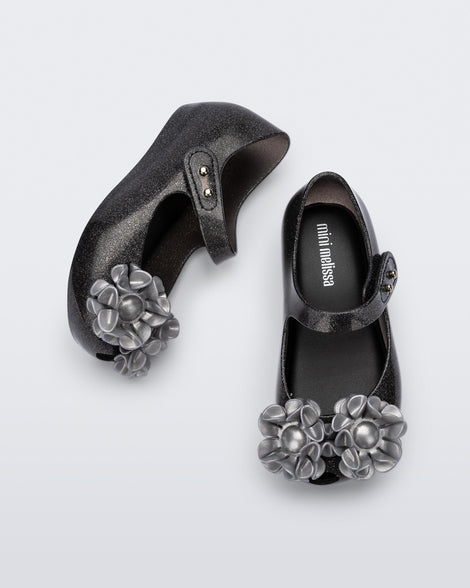 Top and side view of a pair of glitter black baby Ultragirl Springtime flats