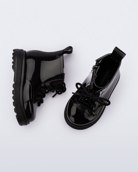 Top and side view of a pair of black Coturno baby boots with black laces.