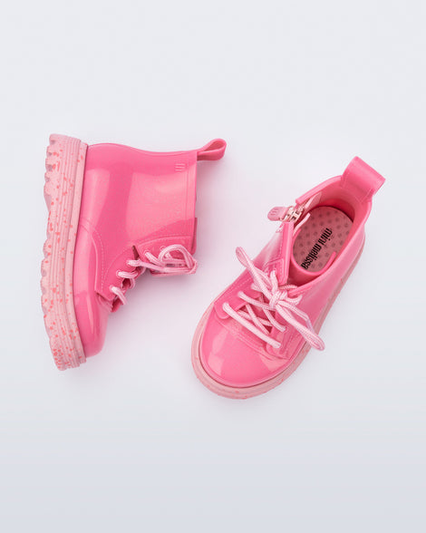 Top and side view of a pair of pink Coturno baby boots with pink laces.