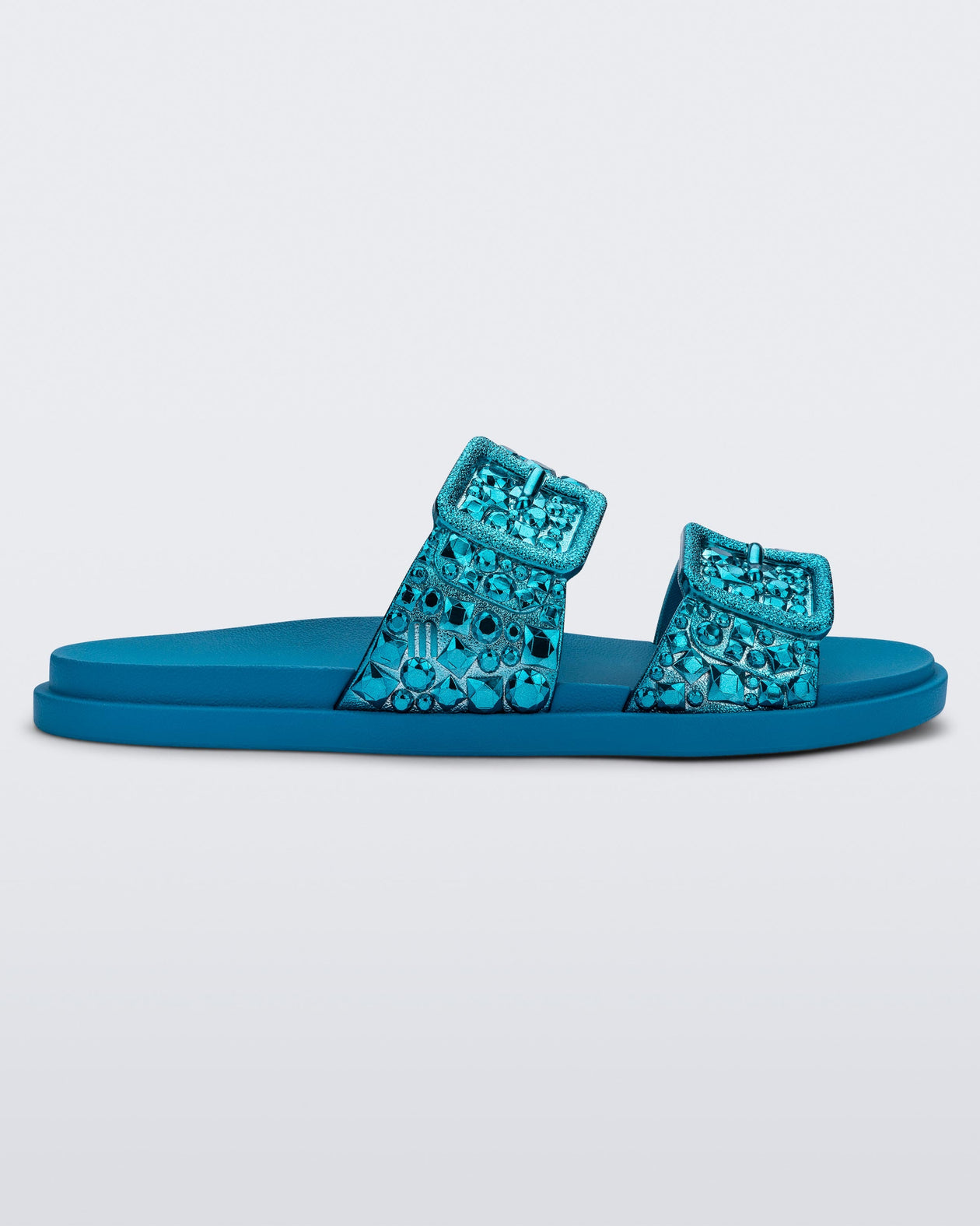 Side view of a blue Lust Slide with metallic buckle straps