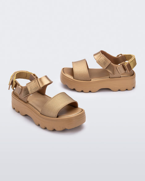 Angled view of a pair of gold kids Kick Off Sandals