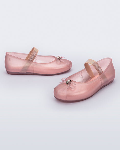 Side and angled view of a pair of pearly pink Sophie kids ballerina flats with bow