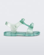 Side view of a pearly green baby Dream Sandal with two bows and gold detail on strap