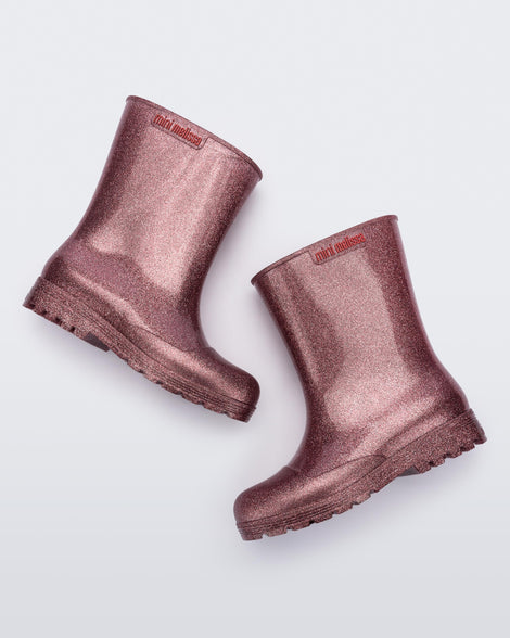 Side angled view of a pair of glitter pink kids Welly rainboots.