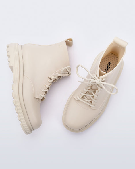 Top and side view of a pair of beige Coturno Soft boots