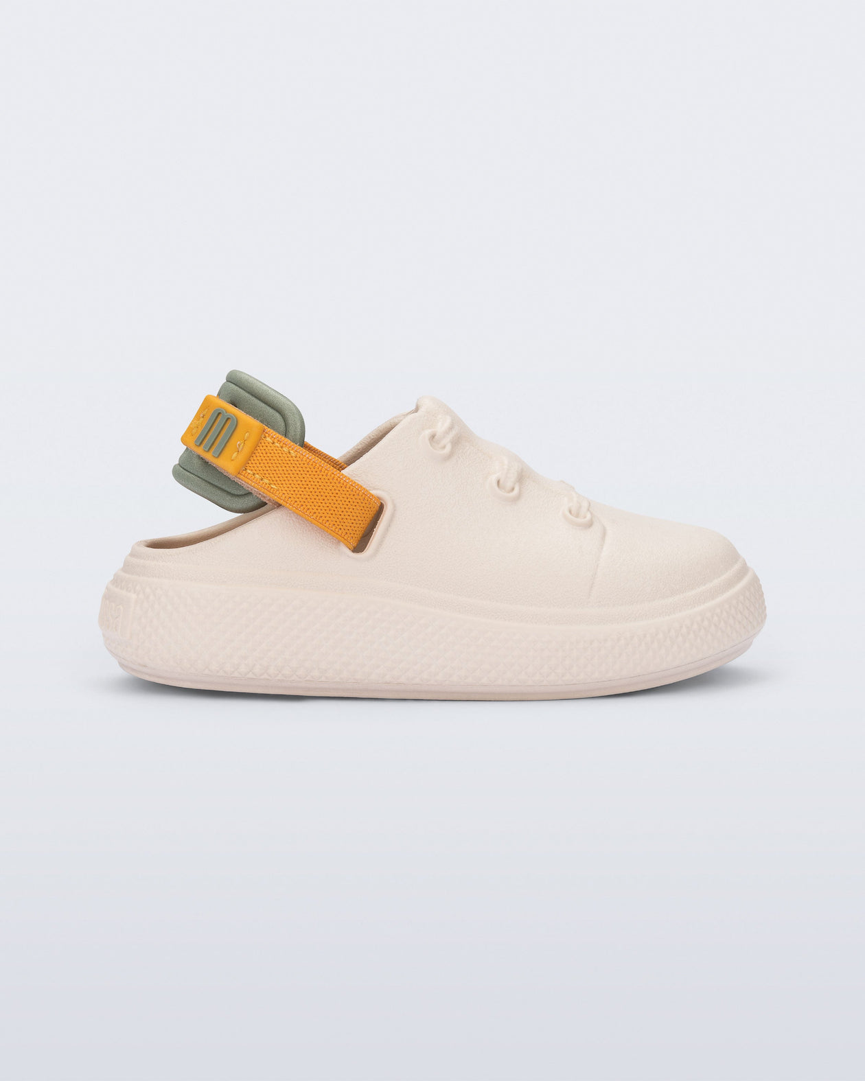 Side view of a beige with orange and green back strap Charlie baby sneaker