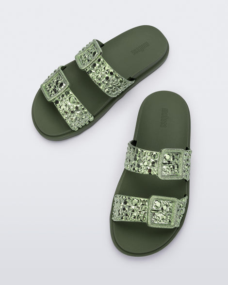 Top view of a pair of green Lust Slide with metallic buckle straps