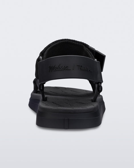 Back view of a black Mini Melissa Papete sandal with black straps.