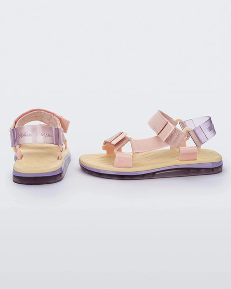 Side and back view of a pair of yellow soled Melissa Papete sandals with pink and transparent purple straps.