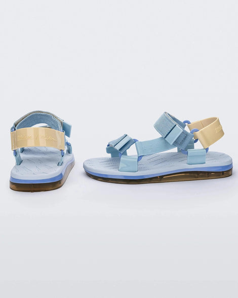 Side and back view of a pair of blue Melissa Papete sandals with blue and beige straps.