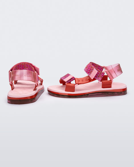 SIde and back view of a pair of pink Melissa Papete sandals with patterned pink, red and transparent pink straps.