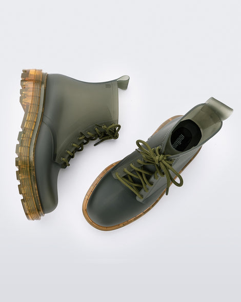 A top and side view of a pair of clear green /yellow Melissa Coturno boots with a green base, laces and a yellow sole.