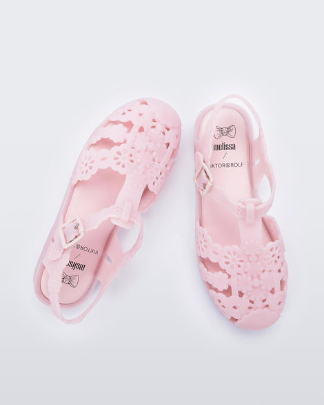 Top view of a pair of Melissa Possession fisherman sandals in pink with cut out lace detail on the straps.