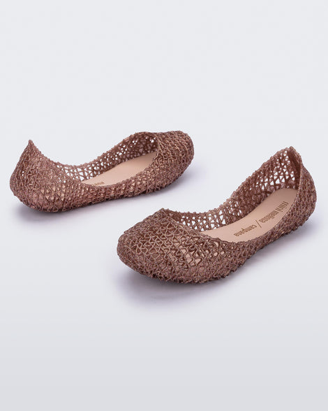 An angled front and back side view of a pair of light pink glitter Mini Melissa Campana flats with an open woven texture.