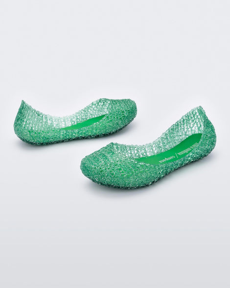 An angled side view of a pair of green Mini Melissa Campana flats with an open woven texture.