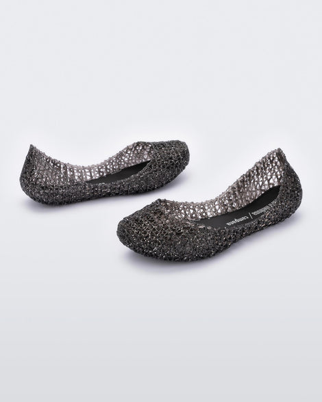 An angled inner and outter view of a pair of black Melissa Campana flats with a glitter design and an open woven texture.