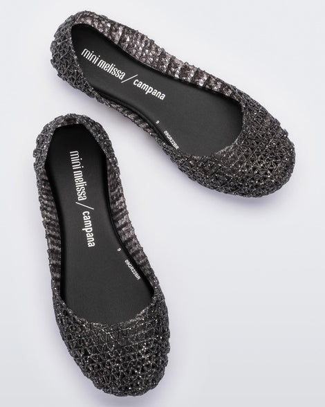 Top view of a pair of black Melissa Campana flats with a glitter design with an open woven texture.