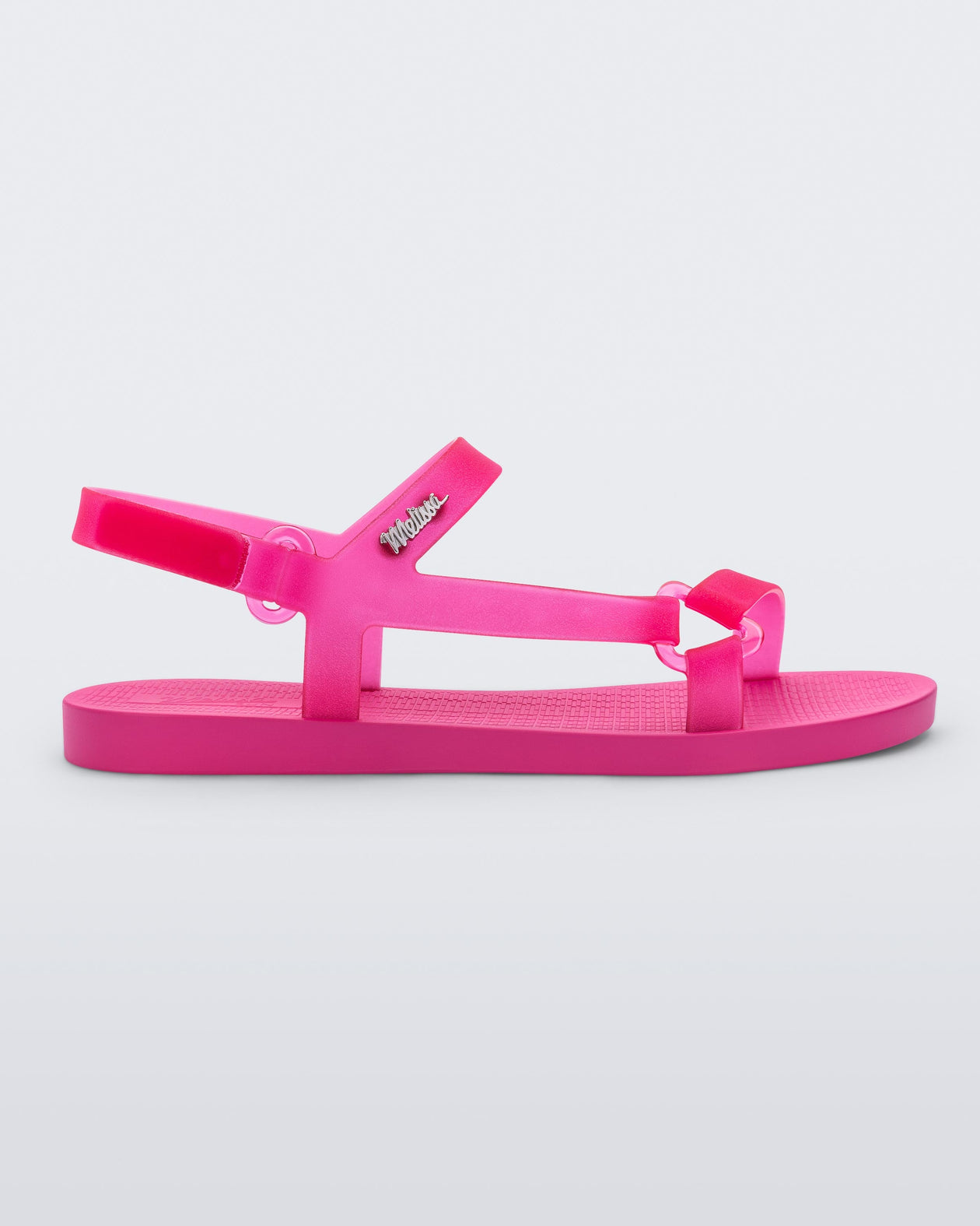 Side view of a Melissa Sun Downtown sandal with transparent pink front cross and back ankle straps and a pink sole. 