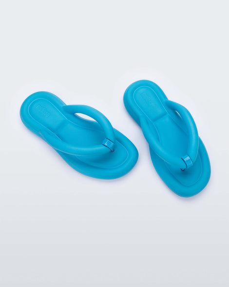 Top view of a pair of sky blue Melissa Free Flip Flops with puffer-like straps.