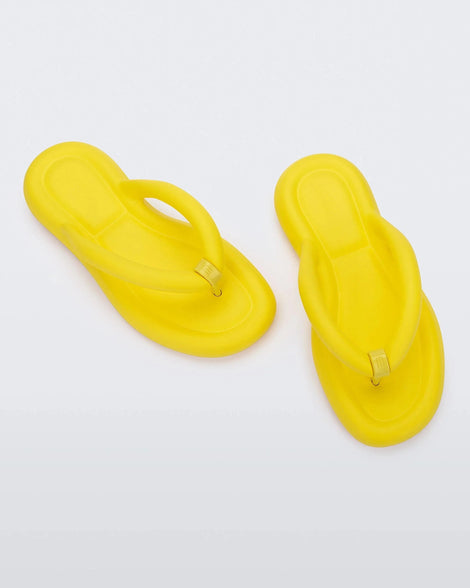 Top view of a pair of yellow Melissa Free Flip Flops with puffer-like straps.