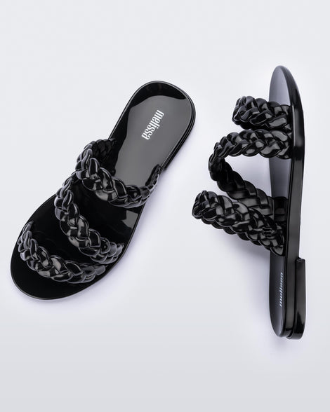 An top and side view of a pair of black Melissa Wrap slide with 3 braid like straps.