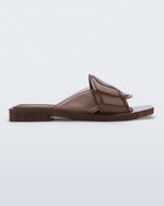 Side view of a brown Melissa Brigitte slide with a weft designed upper strap.