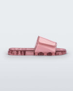 Side view of a pink Melissa Brave Slide with a pink velcro top strap and translucent pink insole.