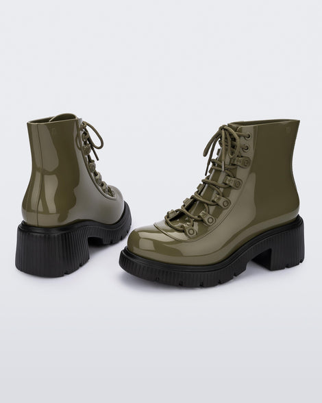 An angled back and side view of a pair of black/green Melissa Cosmo boots with a green base, laces and a black heel sole