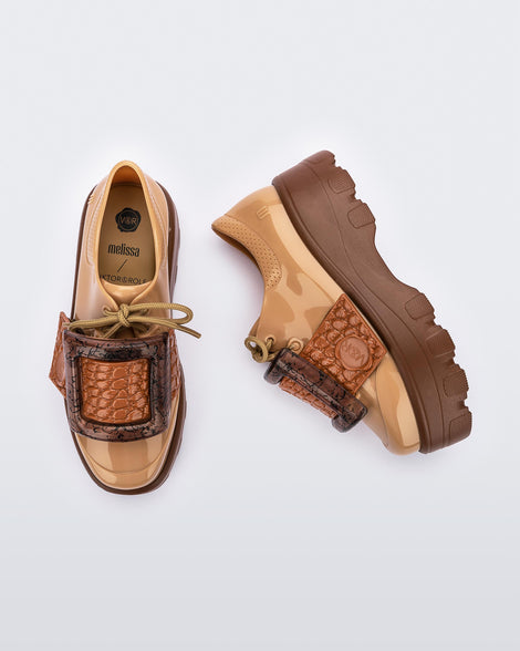 Top and side view of a pair of brown/beige Melissa Buckle Up Kick Off platform sneakers.