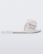 Side view of a white Melissa Babe Garden slide with two flowers on the front strap.