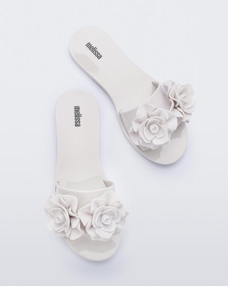 Top view of a pair of white Melissa Babe Garden slides with two flowers on the front strap.