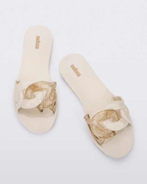 Top view of a pair of beige Melissa Jelly Chain slides with a beige and clear gold glitter chain detail.