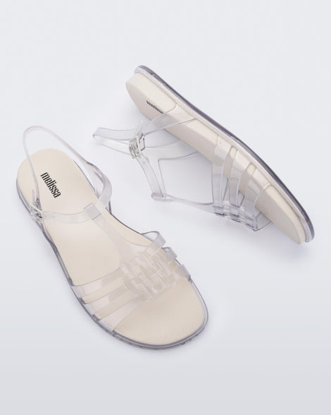 A top and side view of a pair of clear Melissa Party sandals with back ankle strap and buckle closure.