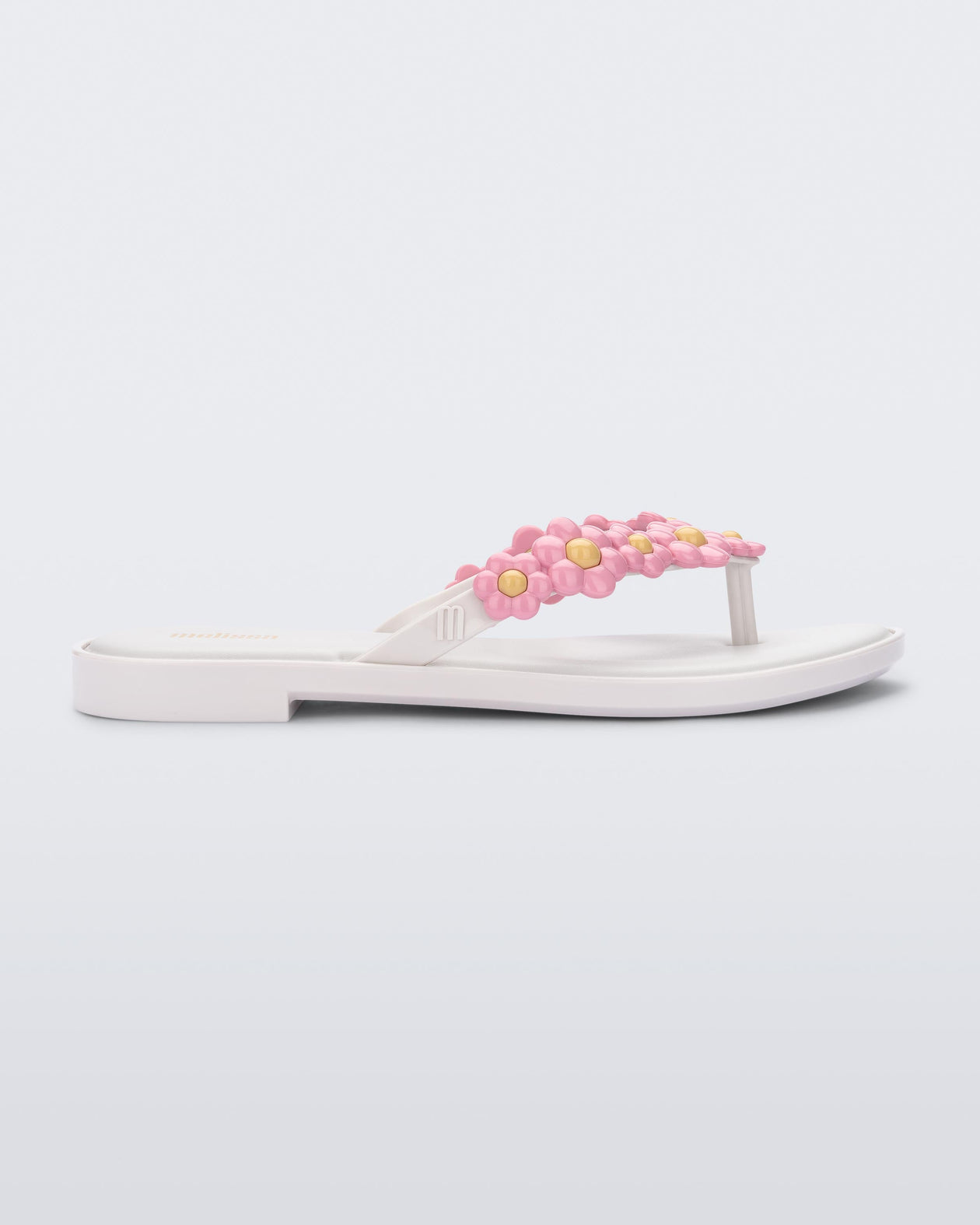 Side view of a white Melissa Spring Flip Flop with pink and yellow flowers on them.