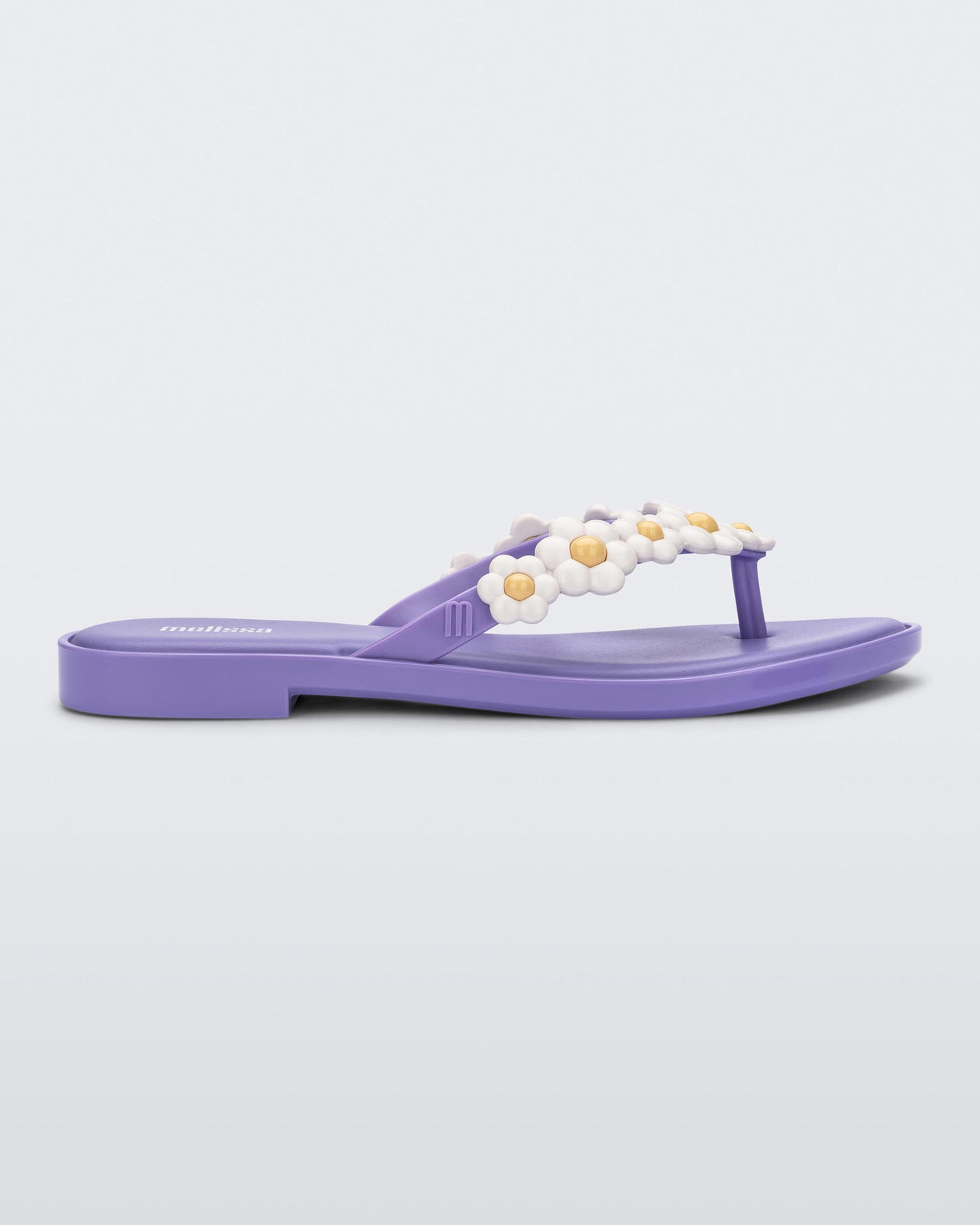 Side view of a lilac / white Melissa Spring Flip Flop with yellow and white flowers on them.