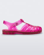 Side view of a transparent pink Melissa Possession sandal with a closed toe front weft design connected to a top strap with a buckle.