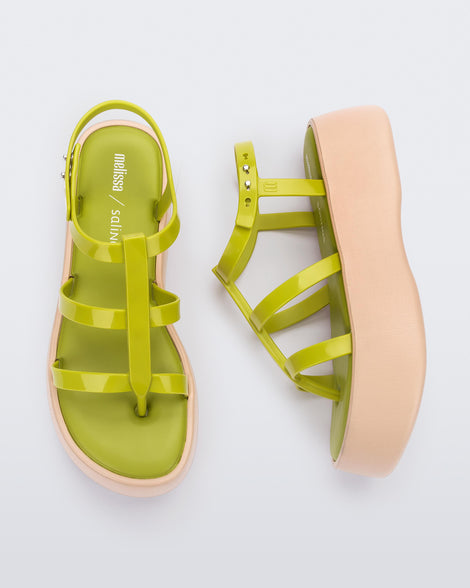 A top and side view of a pair of beige/green Melissa Caribe High Platform sandals with two green front straps joined by a vertical strap intersecting the ankle strap and a beige sole.